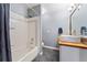 Bathroom with white tiles, tub, white vanity, and modern fixtures at 7120 S Clay St, Littleton, CO 80120