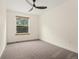 This bright bedroom features a ceiling fan and natural light from the large window overlooking lush greenery at 7120 S Clay St, Littleton, CO 80120