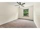 Bedroom featuring a ceiling fan, carpeted floor, and large window at 7120 S Clay St, Littleton, CO 80120
