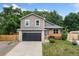 Charming two-story home featuring a modern garage door and cozy front porch at 7120 S Clay St, Littleton, CO 80120