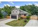 Inviting two-story home with a charming front porch, well-maintained lawn, and a modern garage door at 7120 S Clay St, Littleton, CO 80120