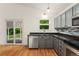 Bright kitchen with stainless steel appliances, dark countertops, and hardwood floors at 7120 S Clay St, Littleton, CO 80120