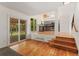 Bright living room with hardwood floors, staircase, sliding glass door, and a view of the kitchen at 7120 S Clay St, Littleton, CO 80120