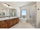 Bathroom with a soaking tub, walk-in shower, and wood cabinets at 5320 Dual Rey Pt, Sedalia, CO 80135