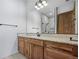Bathroom with wood cabinets and subway tile shower at 5320 Dual Rey Pt, Sedalia, CO 80135