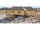Exterior view of a two-story house with a tan exterior and snow on the ground at 5320 Dual Rey Pt, Sedalia, CO 80135