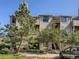 Multi-story condo building with mature trees, stone accents and well-maintained landscaping at 7498 S Alkire St # 202, Littleton, CO 80127