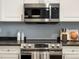 Close-up of a modern stainless steel microwave above a range in a kitchen with ample counter space at 7498 S Alkire St # 202, Littleton, CO 80127