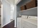 Convenient laundry room setup with washer, dryer, and built-in shelving providing space at 7498 S Alkire St # 202, Littleton, CO 80127