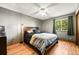 Bedroom featuring hardwood floors, a ceiling fan, and a large window with green curtains at 8386 S Davco Dr, Morrison, CO 80465