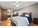 Bedroom with hardwood floors, ceiling fan, dresser with mirror, and ensuite bathroom at 8386 S Davco Dr, Morrison, CO 80465