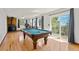 Spacious game room featuring a pool table, wood floors, and a sliding door leading to the deck with nature views at 8386 S Davco Dr, Morrison, CO 80465