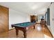 Bright game room featuring a pool table, wood floors, wood wall, and view to the outdoor scenery at 8386 S Davco Dr, Morrison, CO 80465