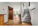 Hallway with hardwood floors leading to stairs, living room with pool table and an outdoor view at 8386 S Davco Dr, Morrison, CO 80465
