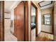 Hallway with hardwood floors leads to a bedroom and bathroom with marble tile flooring at 8386 S Davco Dr, Morrison, CO 80465
