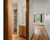 Bright hallway with wood floors leading to a vanity and bedroom with window views at 8386 S Davco Dr, Morrison, CO 80465