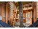 Charming interior featuring wooden walls, a ladder to a loft, and natural light streaming through multiple windows at 8386 S Davco Dr, Morrison, CO 80465