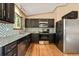Kitchen with stainless steel appliances, dark cabinets, and stone backsplash at 8386 S Davco Dr, Morrison, CO 80465