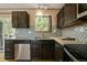 Well-lit kitchen with dark wood cabinetry, stainless steel appliances, and stone countertops at 8386 S Davco Dr, Morrison, CO 80465
