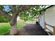Expansive backyard featuring green grass, mature trees, and brick patio at 10297 W Crestone Mtn, Littleton, CO 80127