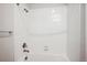 Bathtub and shower combo featuring a rainfall shower head and white tiling at 485 Interlocken Blvd # 209, Broomfield, CO 80021
