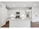 Bright white kitchen featuring an island, modern appliances, and wood-look flooring at 485 Interlocken Blvd # 209, Broomfield, CO 80021