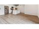 Open kitchen with island, white cabinets, stainless steel appliances, and hardwood flooring at 485 Interlocken Blvd # 209, Broomfield, CO 80021
