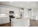 Bright white kitchen featuring an island, modern appliances, and wood-look flooring at 485 Interlocken Blvd # 209, Broomfield, CO 80021