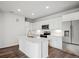 Bright white kitchen featuring an island, modern appliances, and wood-look flooring at 485 Interlocken Blvd # 209, Broomfield, CO 80021