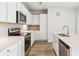 Well-lit kitchen has stainless steel appliances, modern cabinets, a large island, and hard wood floors at 485 Interlocken Blvd # 209, Broomfield, CO 80021