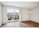 Bright, open living room with sliding glass doors to a balcony and wood-look flooring at 485 Interlocken Blvd # 209, Broomfield, CO 80021