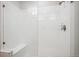 Modern shower with white tiled walls, glass door and a built in bench at 485 Interlocken Blvd # 209, Broomfield, CO 80021