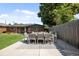 Outdoor dining area in a backyard setting with artificial turf, wooden fence and mature trees and a brick house at 2649 N Cook St, Denver, CO 80205