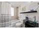 Stylish bathroom featuring a glass bowl sink, shower/tub with elegant curtain and shelf for decorations at 2649 N Cook St, Denver, CO 80205