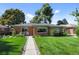 Landscaped front yard featuring a brick home with a walkway leading to a cozy seating area at 2649 N Cook St, Denver, CO 80205