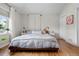 Bright main bedroom with wood floors, large window, and minimalist decor at 2649 N Cook St, Denver, CO 80205
