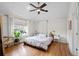 Bright main bedroom with wood floors, ceiling fan, large window, and minimalist decor at 2649 N Cook St, Denver, CO 80205