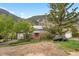 Cozy gray home with solar panels, a red door, mountain views, and natural landscaping at 1777 Main St, Georgetown, CO 80444