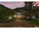 Charming gray home with solar panels, and inviting red door at dusk at 1777 Main St, Georgetown, CO 80444