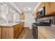 Galley kitchen with wood cabinetry, black appliances, and a charming country feel at 1777 Main St, Georgetown, CO 80444
