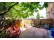 Cozy backyard with a stone patio, wooden fence, and mature trees offering shade, creating a private outdoor space at 12632 W Virginia Ave, Lakewood, CO 80228