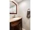 Bathroom featuring granite countertop, wood vanity, framed mirror, and towel ring at 12632 W Virginia Ave, Lakewood, CO 80228