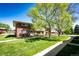A neat row of townhomes with brick facades and green lawns, sheltered by large, leafy trees at 12632 W Virginia Ave, Lakewood, CO 80228