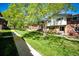 Attractive townhomes with manicured lawns and mature trees lining a walkway, offering a tranquil setting at 12632 W Virginia Ave, Lakewood, CO 80228