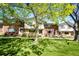 Charming townhomes featuring brick and siding, shaded by mature trees and a well-maintained green lawn at 12632 W Virginia Ave, Lakewood, CO 80228