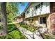 Quaint townhouse exteriors featuring brick and siding, with meticulously maintained greenery and tree coverage at 12632 W Virginia Ave, Lakewood, CO 80228
