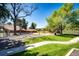 Neighborhood playground with green grass, mature trees, and a variety of play equipment for children at 12632 W Virginia Ave, Lakewood, CO 80228