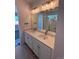 Bathroom featuring a dual vanity, large mirror with modern lighting, and a walk-in shower at 6077 Caribou Dr, Brighton, CO 80601