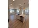 Spacious kitchen island with white cabinets, stainless steel dishwasher, and pendant lighting at 6077 Caribou Dr, Brighton, CO 80601