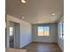 Bright and open living room with light wood flooring and ample natural light from large windows at 6077 Caribou Dr, Brighton, CO 80601